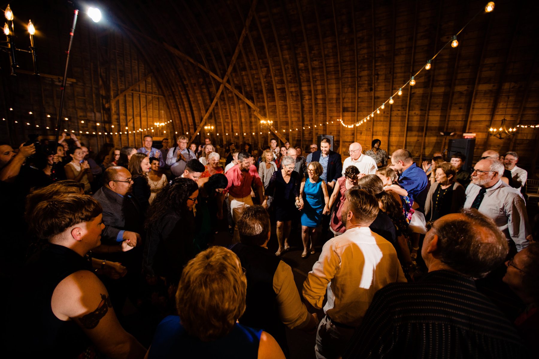 Guests dancing in the barn at night under string lights