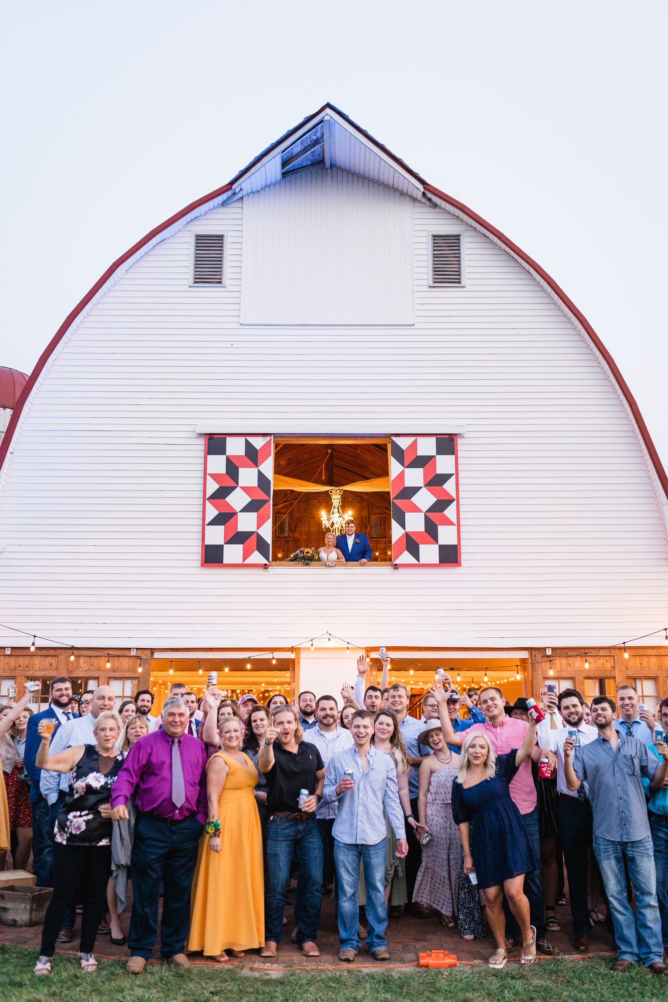 The wedding party framed in the open barn doorway.