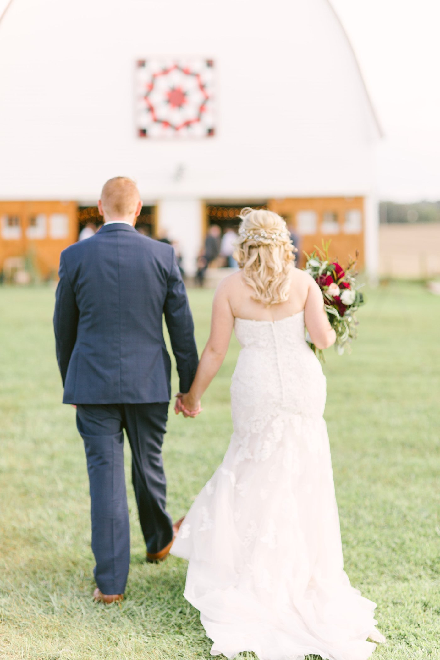 A couple walking together toward the barn.