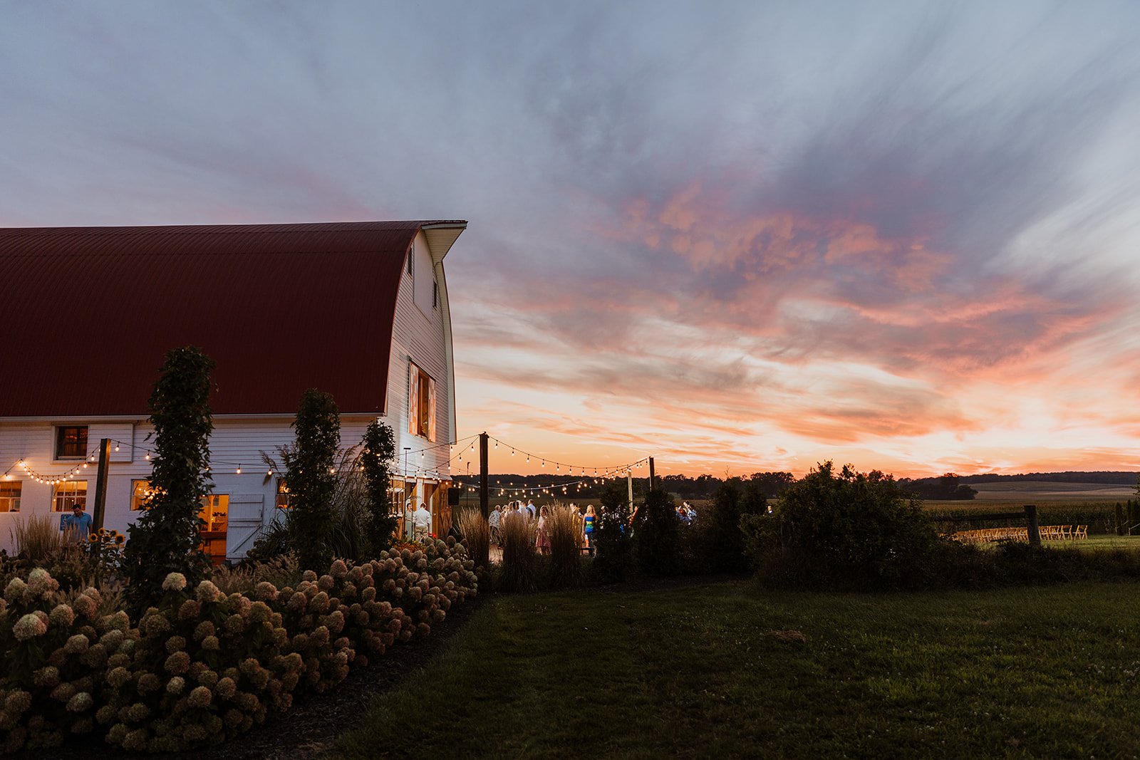 The white barn at golden hour with a dramatic sunset sky