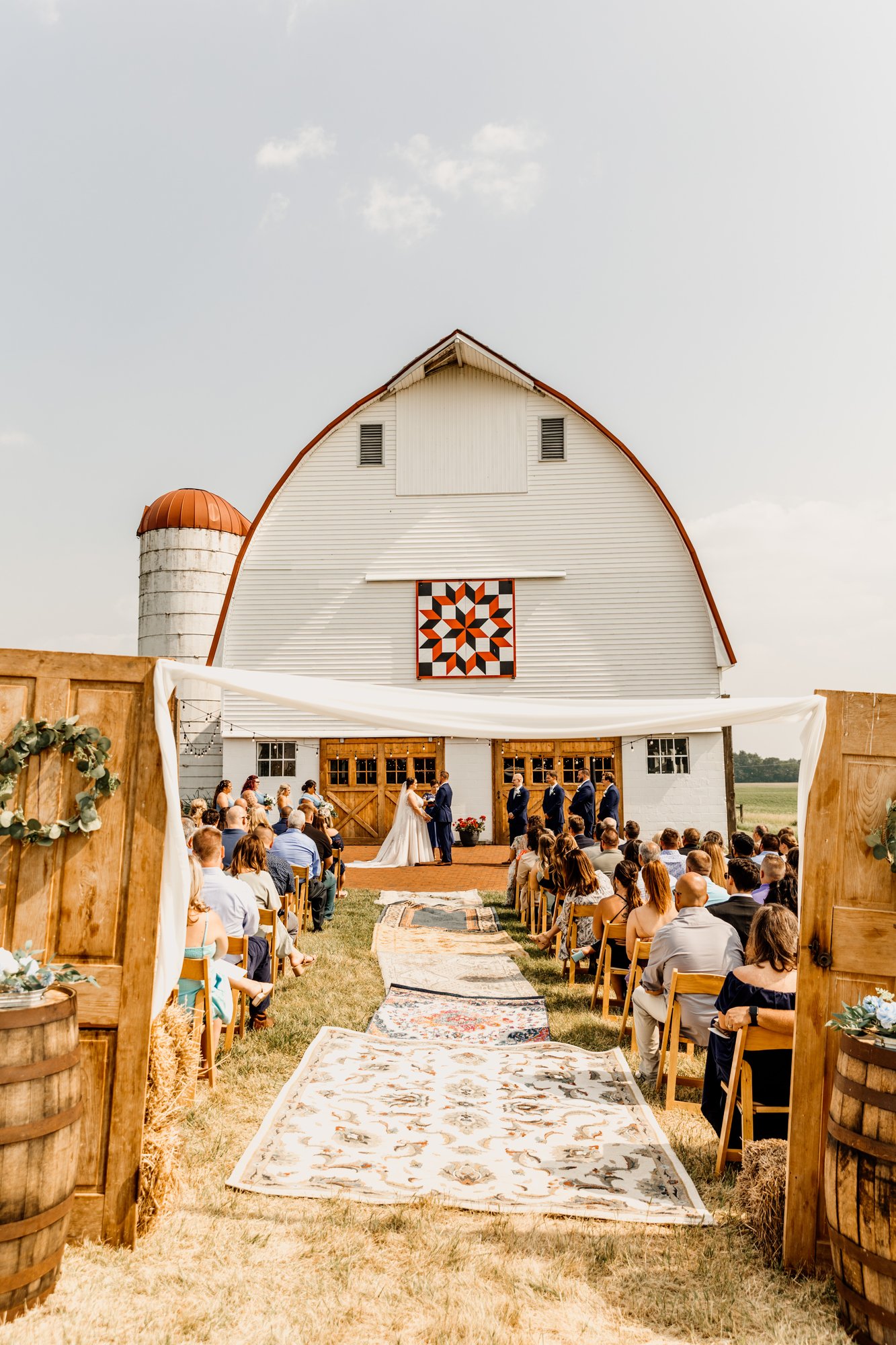 A ceremony inside the barn, guests seated along the aisle.