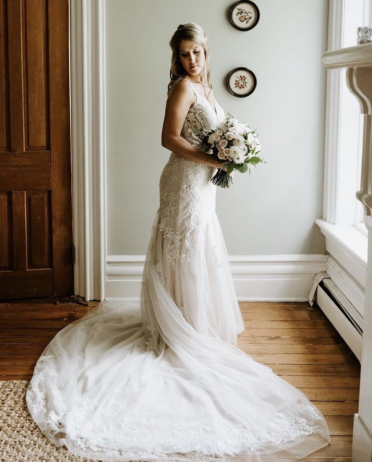 A full-length bridal portrait in the farmhouse doorway.
