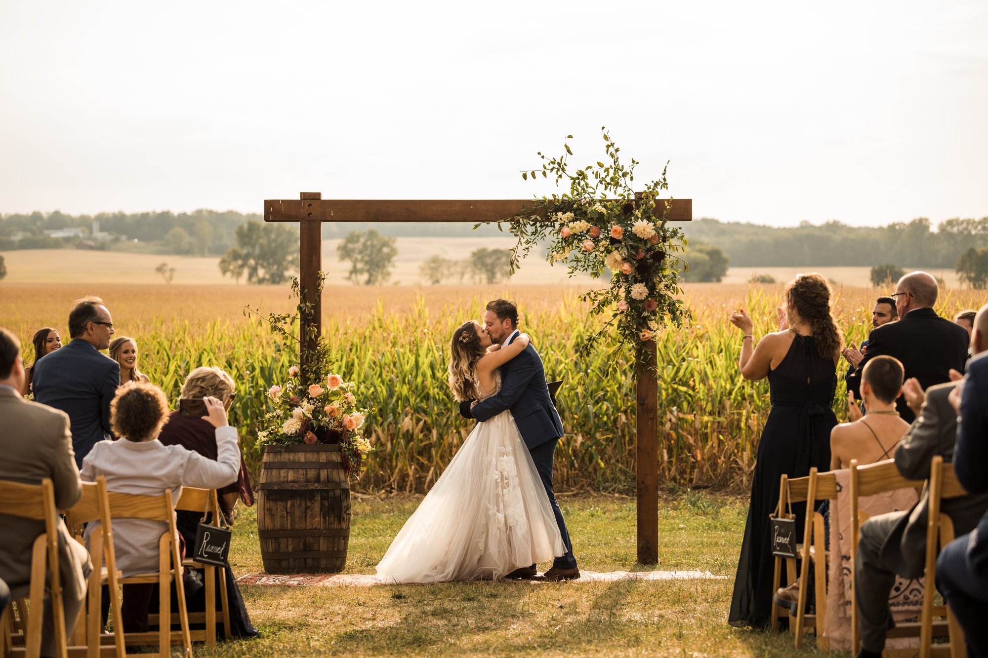 A wide outdoor ceremony in the Wren Farm field with guests gathered beneath the open sky.