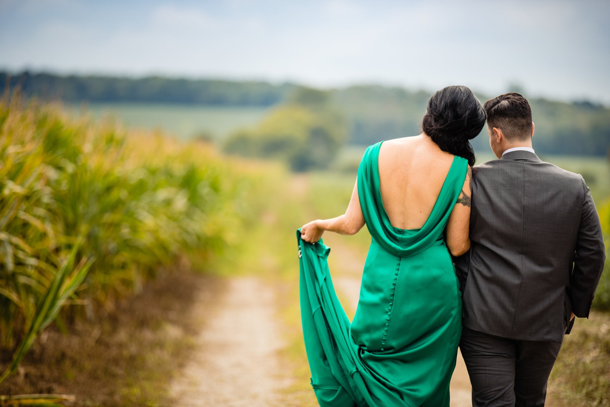 A couple walking a path beside the cornfield.