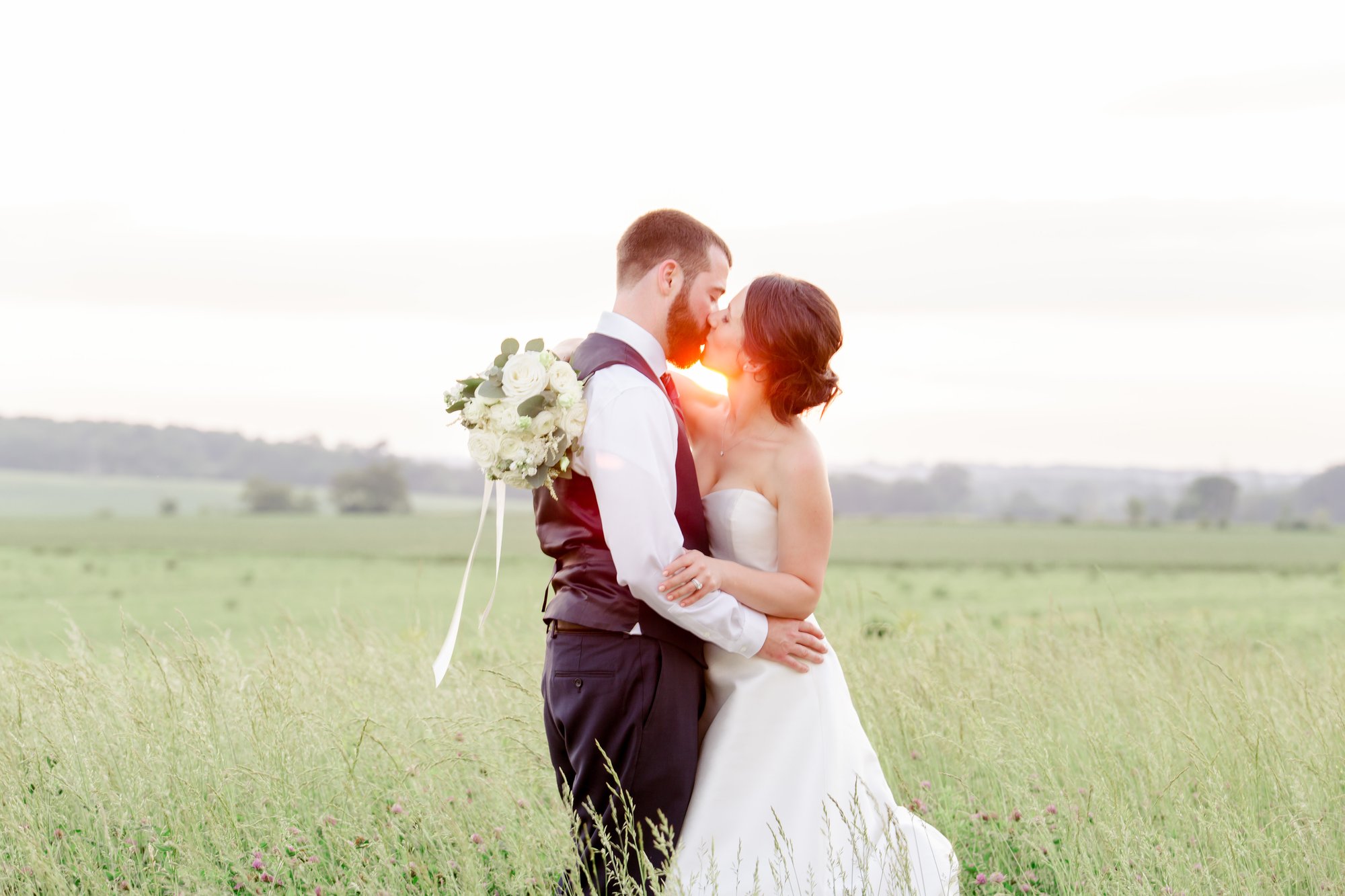 A newlywed couple in the golden field at the end of the day.