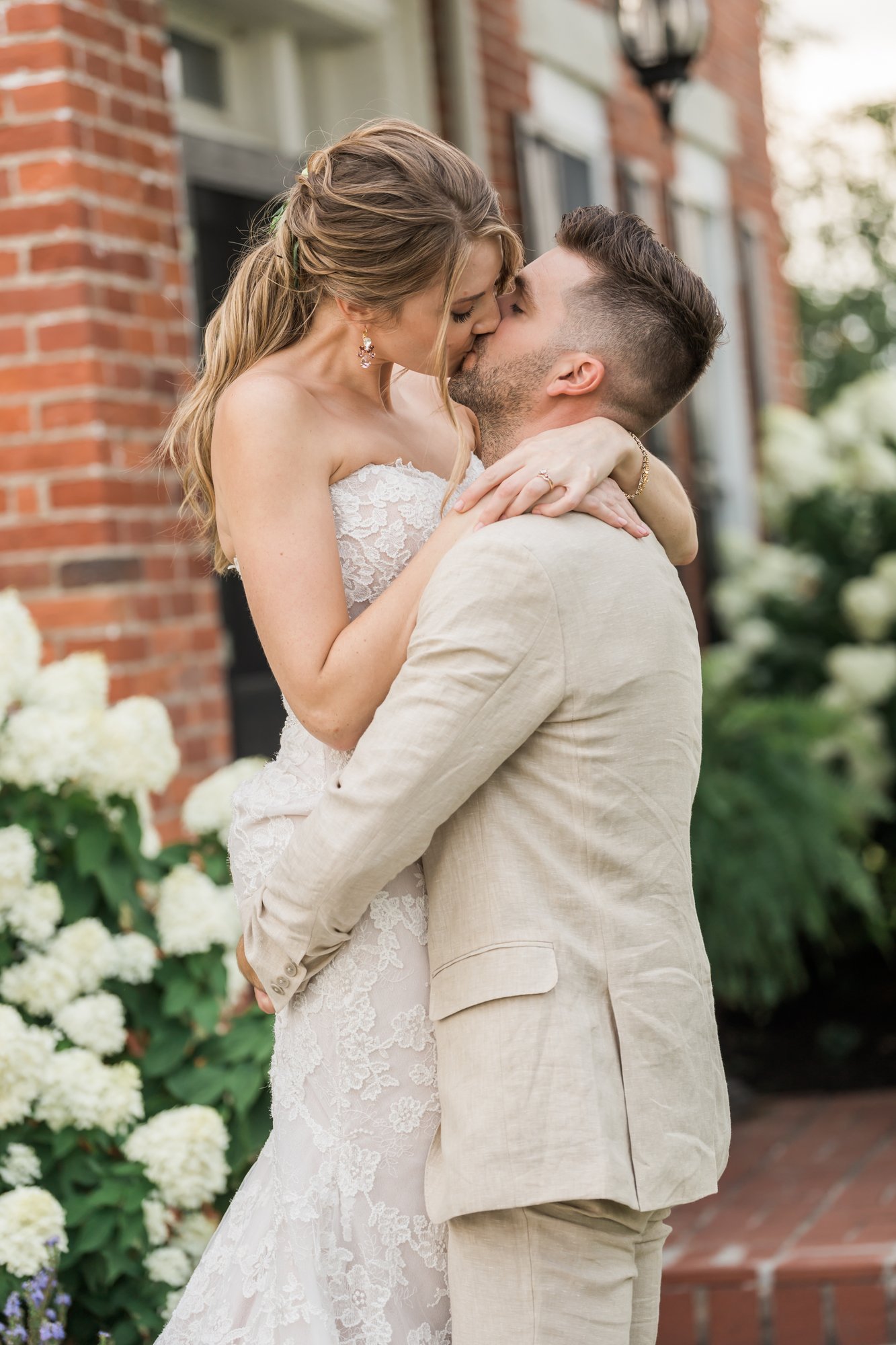 A couple standing among blooming hydrangeas.