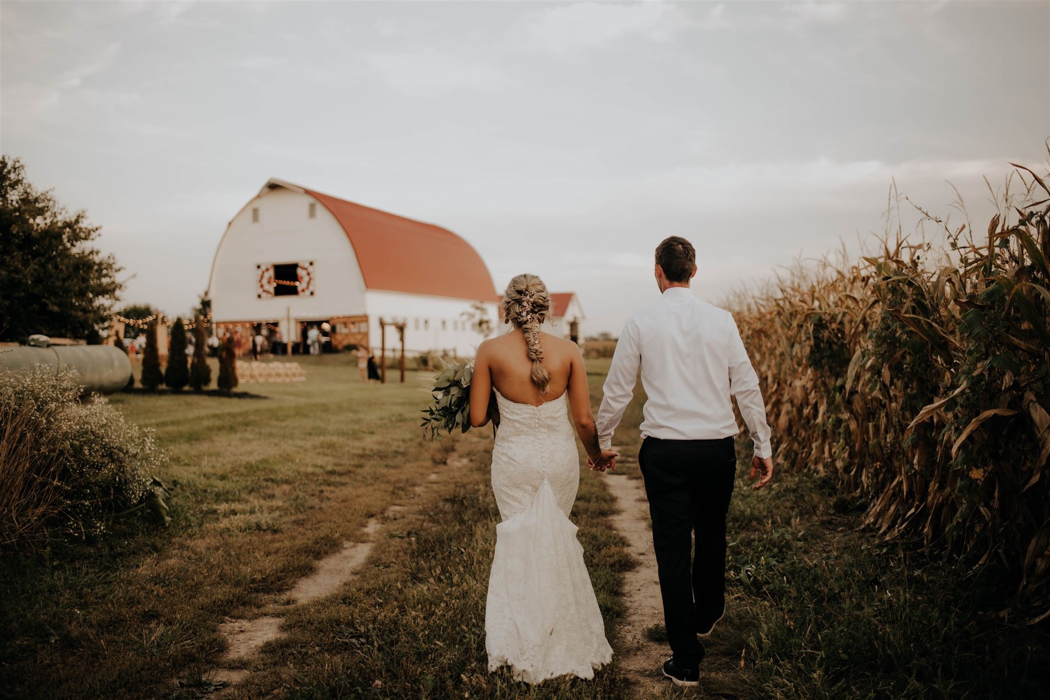 A couple walking the lane back toward the barn on an autumn evening.