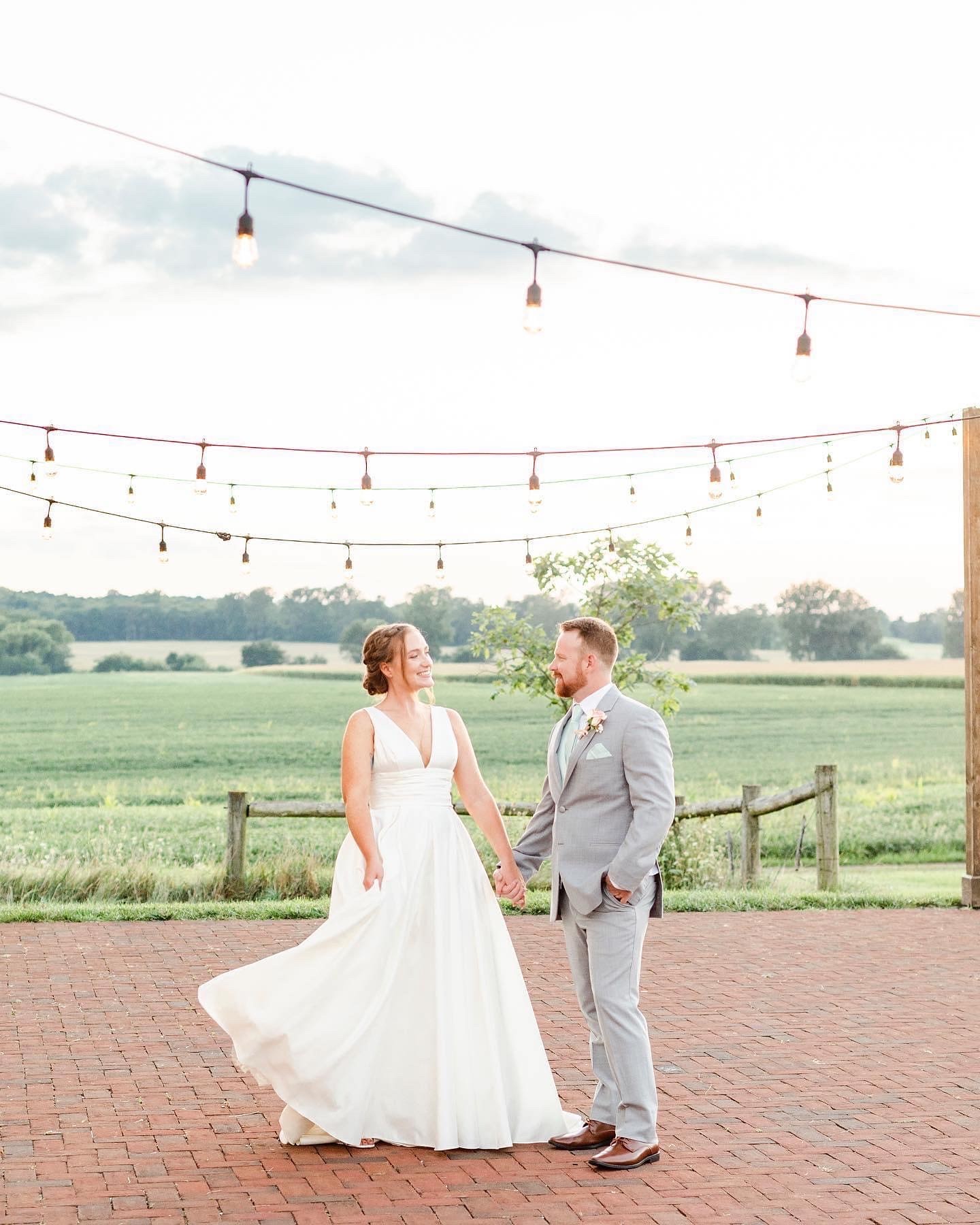 A couple on the brick patio beneath the string lights.
