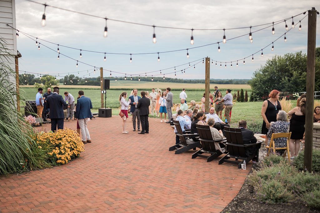 Guests out on the brick patio under strings of light.