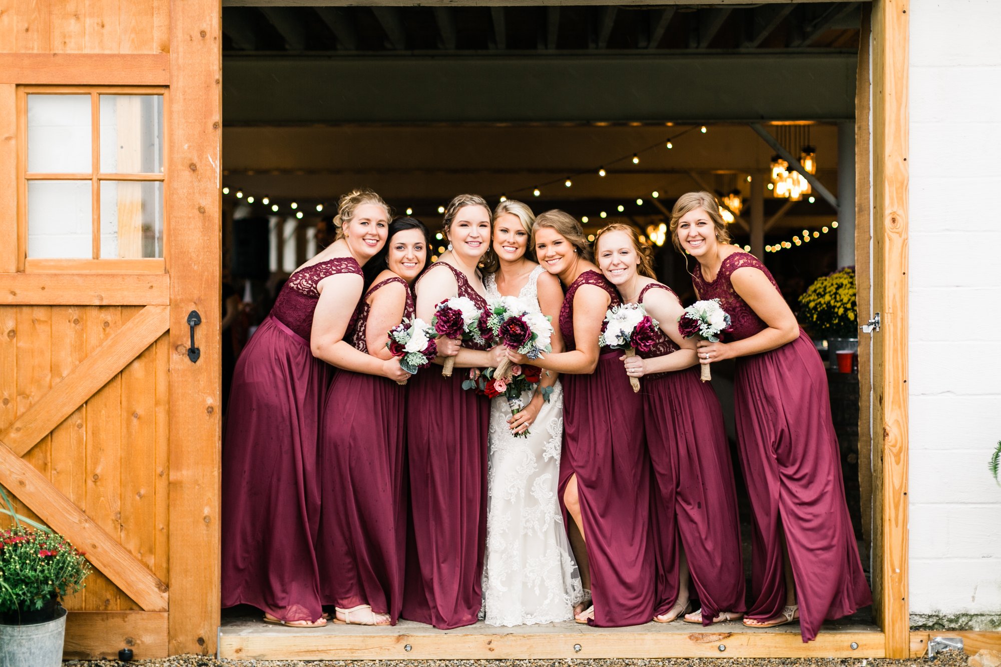 Bridesmaids gathered in the open barn doorway.
