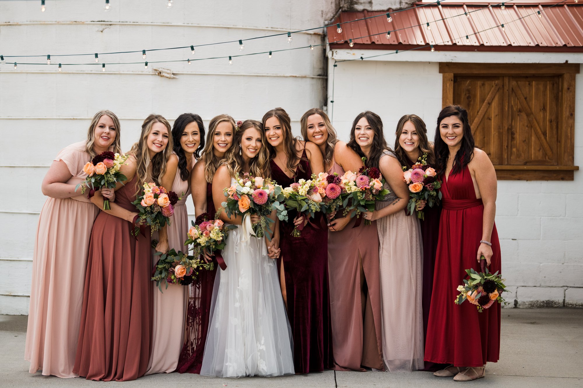 Bridesmaids holding their bouquets outside the barn.
