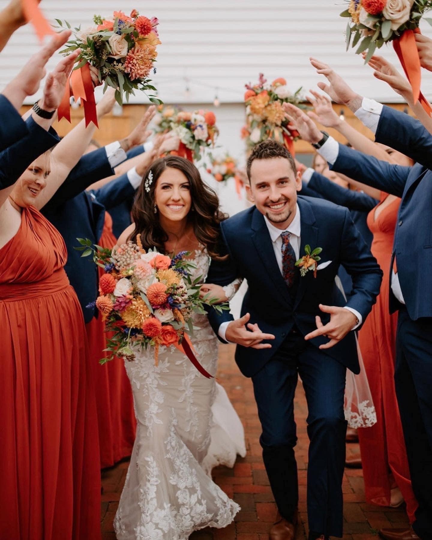 The wedding party celebrating in rust and burgundy on an autumn afternoon.